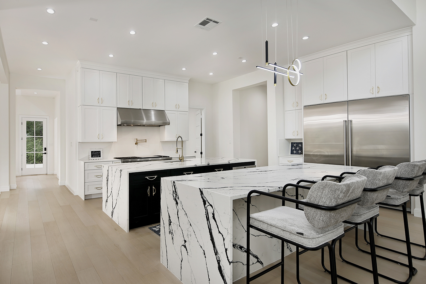 Chef's kitchen with waterfall marble islands and Wolf range